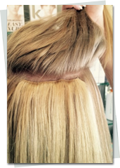 View of tape in hair extensions being installed on a clients hair