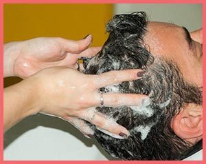 Person getting their hair washed as part of hair repair after summer regimen