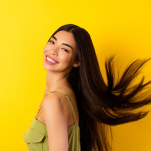 Profile portrait of cheerful adorable person beaming smile flying black hair isolated on yellow color background