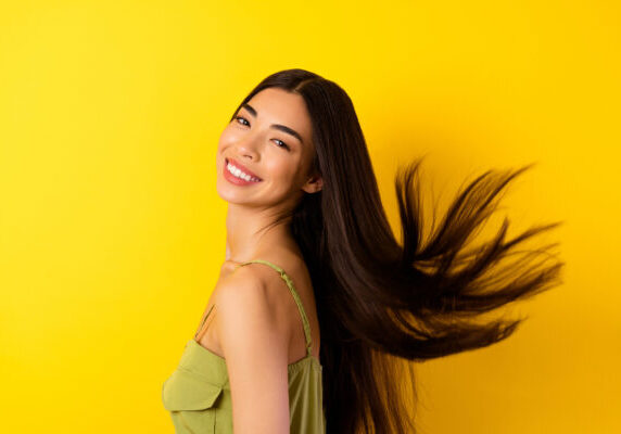 Profile portrait of cheerful adorable person beaming smile flying black hair isolated on yellow color background